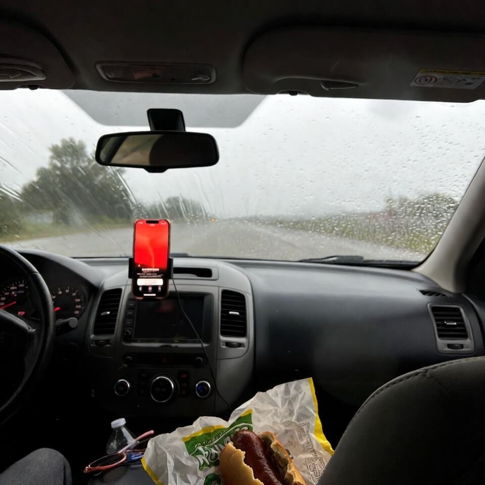 The phone mounted on the dash shows a bright